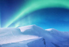 挪威洛福敦群岛上的北极光。山上绿色的北极光。夜晚的天空与极光。夜冬天风景与极光。挪威的自然背景