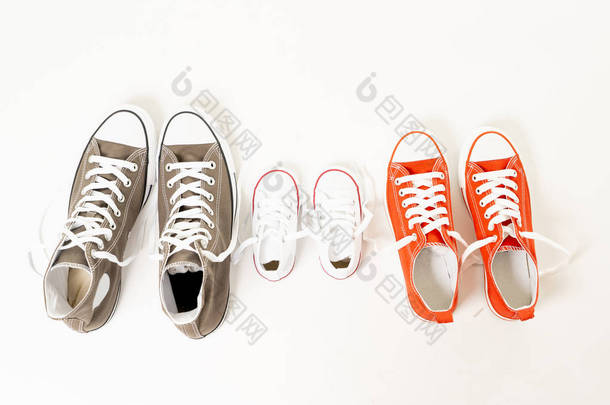 在家庭<strong>育儿</strong>教育和生活方式概念中, 父女母女在不同尺寸的白色<strong>背景</strong>复制空间上隔离的胶鞋运动鞋的概念形象.