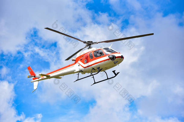 直升机在天空飞行/白色红色飞行直升机在蓝天与云好空气明亮的天-直升机抢救