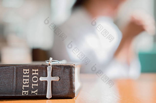 基督教妇女祈祷神圣的圣经。双手折叠在祈祷圣经在教会概念