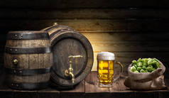 木桌上的啤酒杯和一小桶啤酒。工艺啤酒厂.