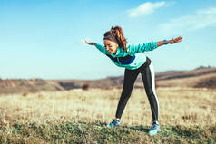 年轻健身妇女做伸展运动后, 户外慢跑
