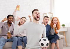快乐的足球迷在电视上观看比赛