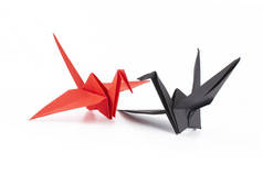 红色和黑色折纸鹤隔离在白色