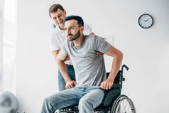 物理治疗师在医院帮助轮椅残疾男子康复