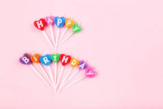 粉红色背景上的生日快乐蜡烛