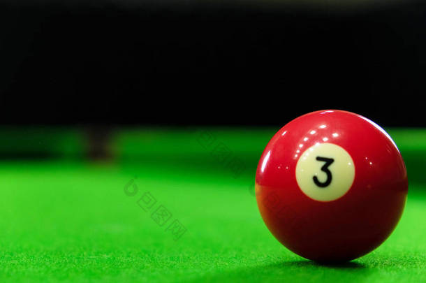 Close-up photos of billiard ball, number 3 and green floor
