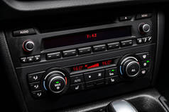 汽车黑色内饰特写：仪表盘与温度，时钟，调整鼓风机，空调等按钮。软对焦
