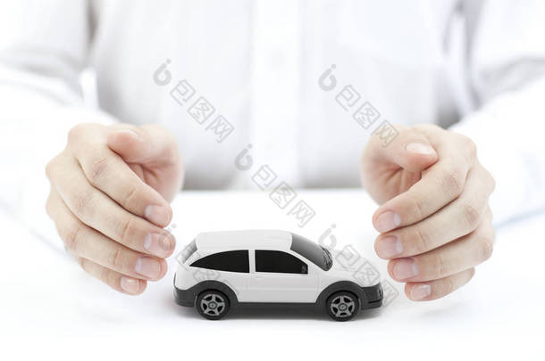 汽车保险的概念与白色汽车玩具覆盖的手