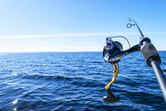 钓鱼杆旋转与线特写。渔杆在渔船上的钓鱼竿，由于捕鱼日。钓鱼竿环。渔具。钓鱼纺纱卷轴.