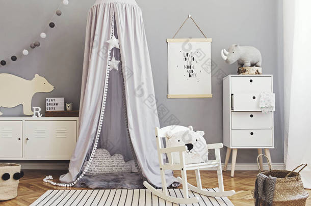 时尚的斯堪的纳维亚<strong>新生</strong>儿房，有仿制<strong>海报</strong>、白色设计家具、天然玩具、挂有星星的灰色顶篷、枕头、配饰和泰迪熊。可爱的儿童内饰装饰.