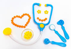 医学概念。医生的儿童玩具。心脏是橙色的药片.
