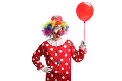 欢快的小丑拿着一个红色的气球