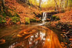 秋天的风景。五颜六色的树木和美丽的瀑布在深