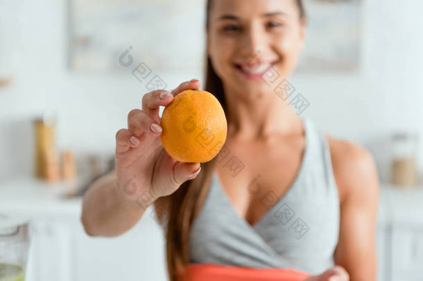 <strong>选择性</strong>的焦点快乐年轻女子拿着美味的橙子