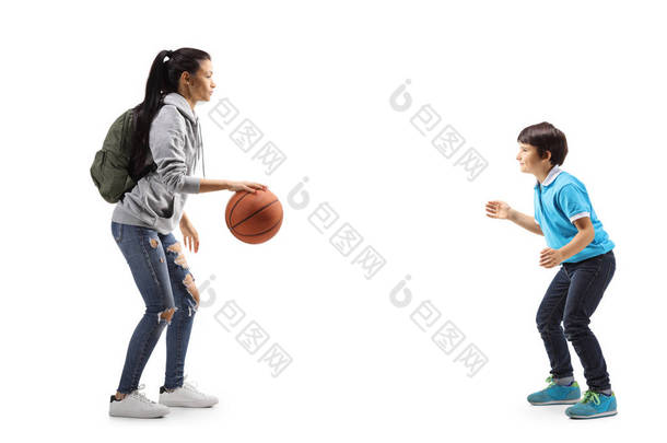 女学生和一个小男孩在打篮球