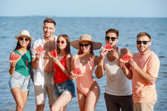 快乐的朋友在度假村的海边吃西瓜