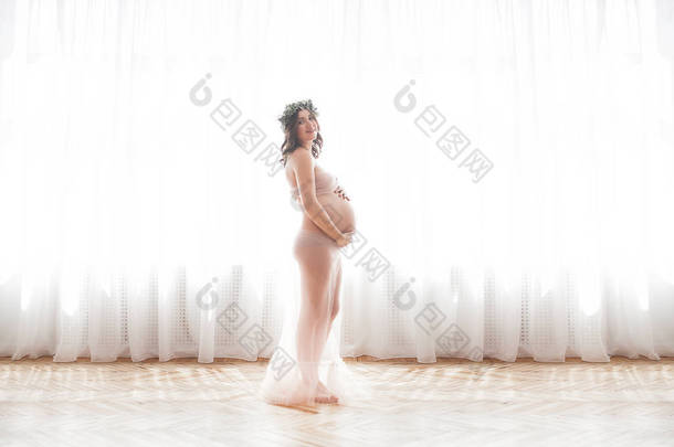 美丽的孕妇在中性背景。期待特写图片。未来母亲肖像在柔和的背景.