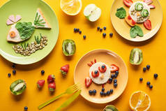 在五颜六色的橙色背景上用食物制成的花哨动物的盘子的顶视图