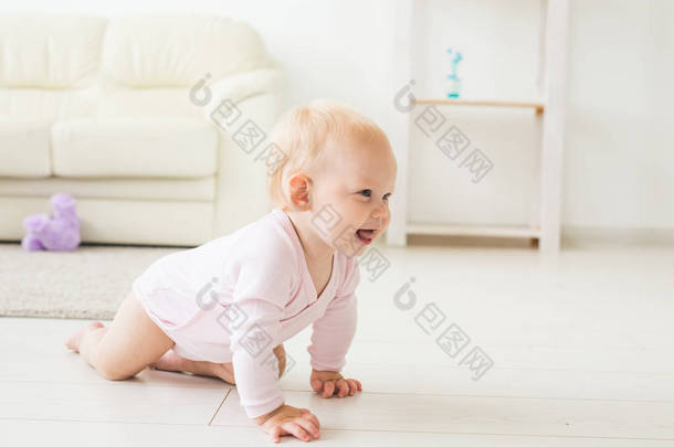 <strong>微笑爬行</strong>的女婴在家里在地板上