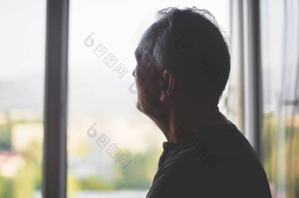 一个老人在窗户背景的剪影。老年。抑郁症<strong>领取</strong>者。退休孤独.