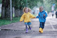 孩子们跑在雨衣/夏季公园，下雨，散步兄弟姐妹，儿童男孩和女孩