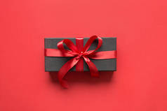 红皮红丝带的黑色礼品盒.