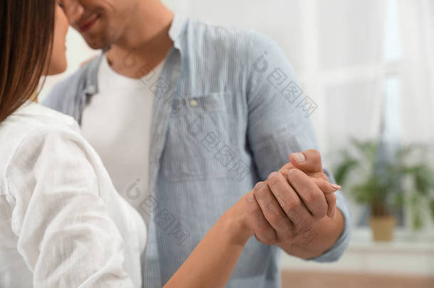 Happy young couple dancing together at home, closeup