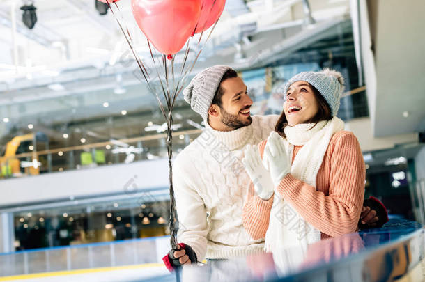 情人节当天，一对红心气球的兴奋夫妇在溜冰场上<strong>消磨</strong>时光