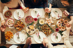 圣诞期间，一群人坐在餐桌前，手拉手祈祷，抄写空间，请看上图