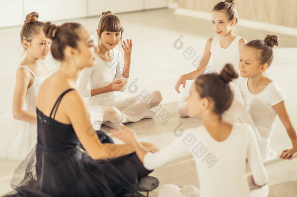穿着短裙的女人和孩子们一起坐在地板上