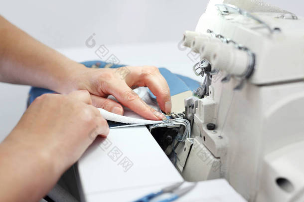 女裁缝在缝纫机上缝衣服。女裁缝缝在外锁上.一个女人在服装厂工作.