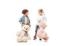 可爱的多文化孩子抱着泰迪熊，白色的