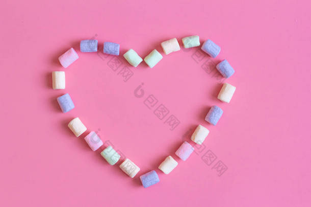 文字,快乐,心形,彩色棉花糖,粉红背景,宏观. 软绵绵的棉花糖质感与柔和的颜色紧密相连
