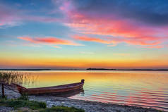 夕阳西下的湖面,沙滩上的木船.