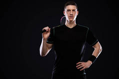 羽毛球运动员穿着运动服，背景是黑色的球拍和羽毛球。2.奥林匹克运动会.