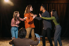 多文化男女演员在剧场的舞台上排练打架