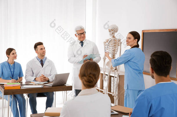 在课堂上学习人体骨骼解剖学的医学生和教授