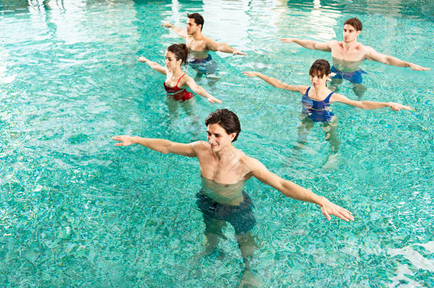 在游泳池进行水上健美操时，教练与年轻人一起练习的高<strong>视角视角</strong>