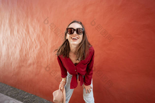 红墙背景上一个时髦女人的画像