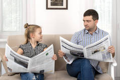 杀了一个女儿和爸爸一起呆在家里他们坐在沙发上，用同样的方式一起看报纸。女儿模仿她的父亲.