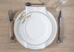 传统的餐桌设置。两个白盘，餐巾，锻造的刀，叉子，勺子，一套酒杯