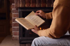 男人在家里壁炉边看书，特写