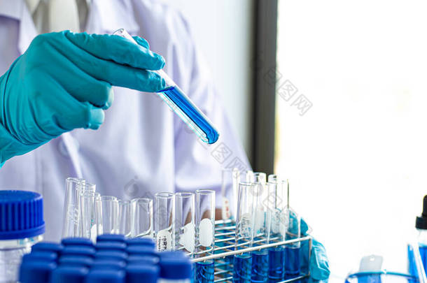科学家携带蓝色化学试管，准备在科学实验室、科学家和实验室概念研究中测定化学成份和生物质量.