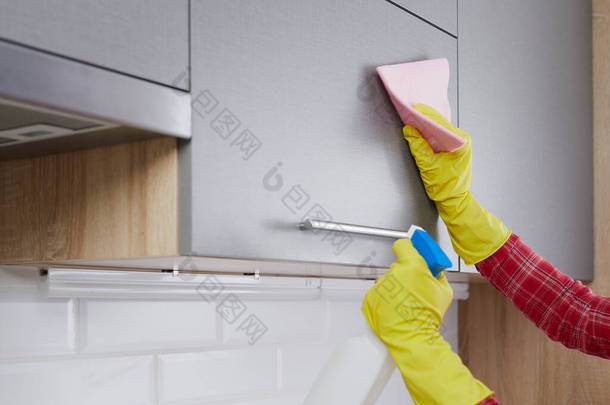 做清洁厨房的女人用粉色<strong>抹布</strong>和<strong>洗</strong>涤剂在厨房里<strong>洗</strong>黄色手套。清扫房屋