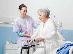 这名妇女笑着向医院的一位老年病人提供帮助的专业护士，靠的是一位散步者