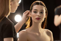 化妆艺术家的选择焦点触摸年轻模特的头发