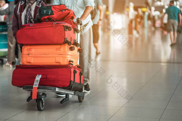 旅客们正步行把行李拖到现代化的机场候机楼去新的地方。后视镜复制空间。行李、旅客、旅游、机场、步行、度假概念.