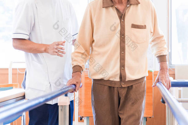 老年人在康复设施中行走，同时由护理人员照看的老年人