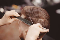 特写，主理理发师用剪刀梳头做发型。概念理发店